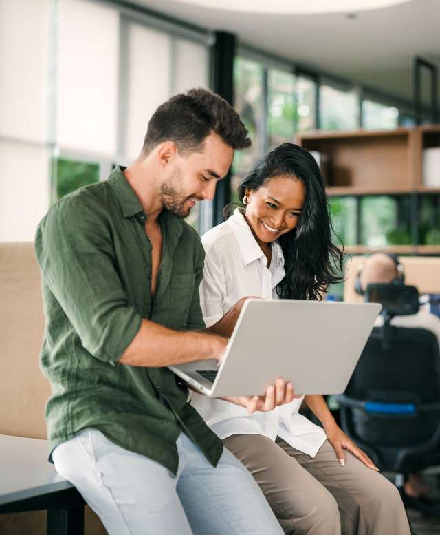 Male & female professionals sat on a desk reviewing work
