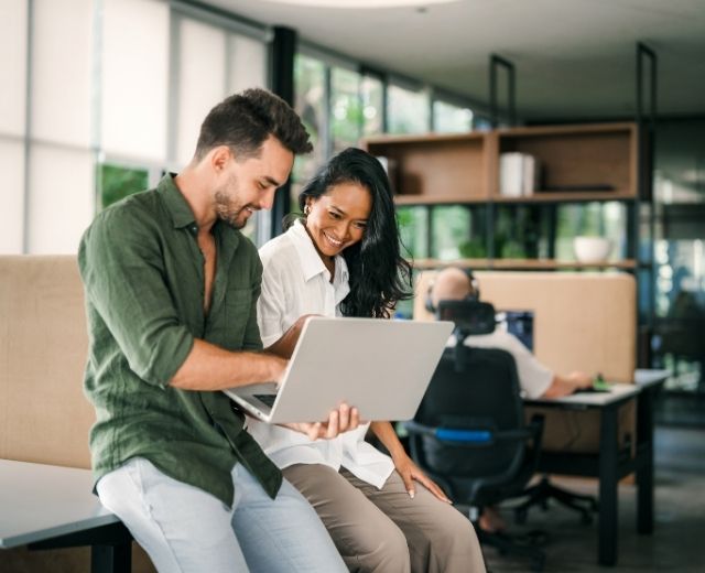 Male & female professionals sat on a desk